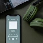 pexels-photo-6686455-6686455 Modern smartphone and green headphones next to a magazine, showcasing technology and lifestyle.